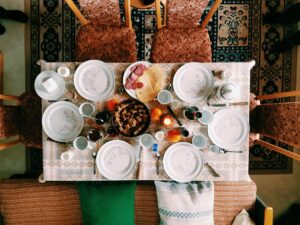 high angle photography of dinner set on table surrounded with padded chairs