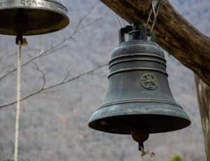 close up of retro iron bell hanging on wood bar